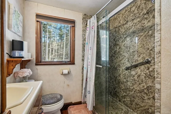 a bathroom with a toilet and a shower