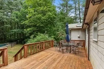 a balcony with wooden floor table and chairs