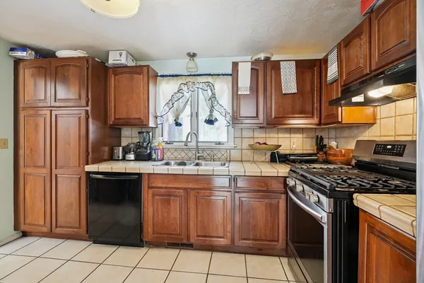 a kitchen with a stove sink and cabinets