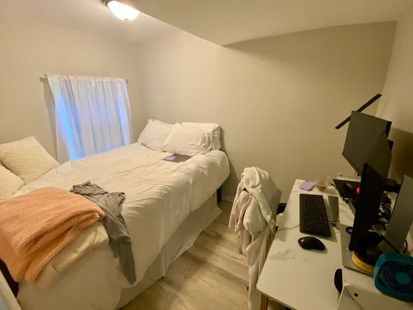 a bedroom with a bed and a flat tv screen on a dresser