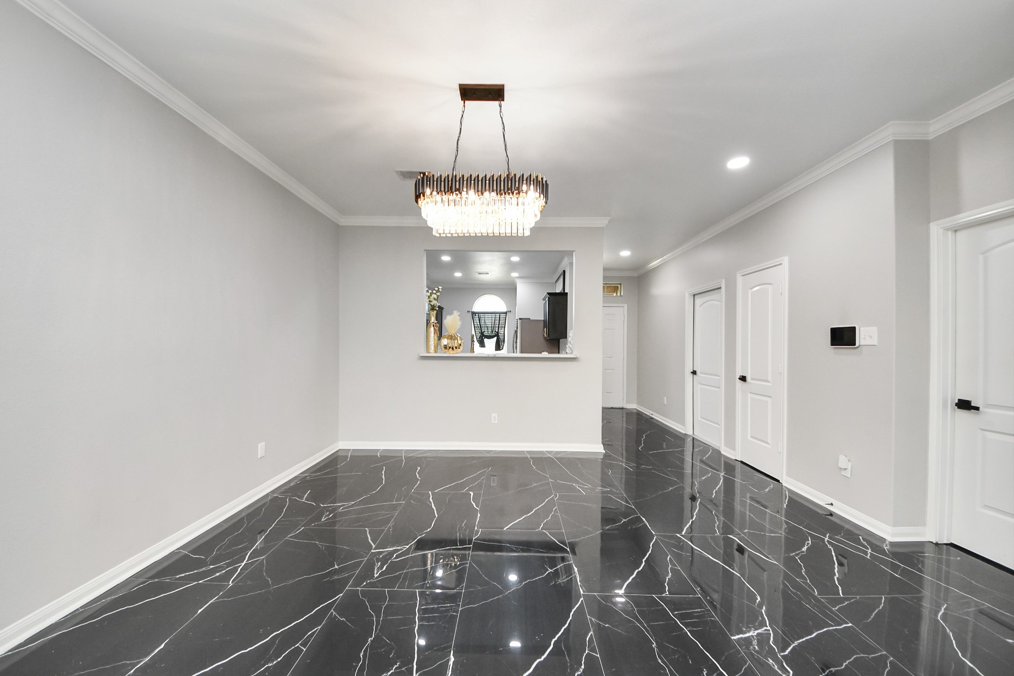 6931 Primrose Road Baytown, TX 77521 - Photo 16 of 50 Formal dining area with elegant chandelier, modern flooring, and open view to kitchen.