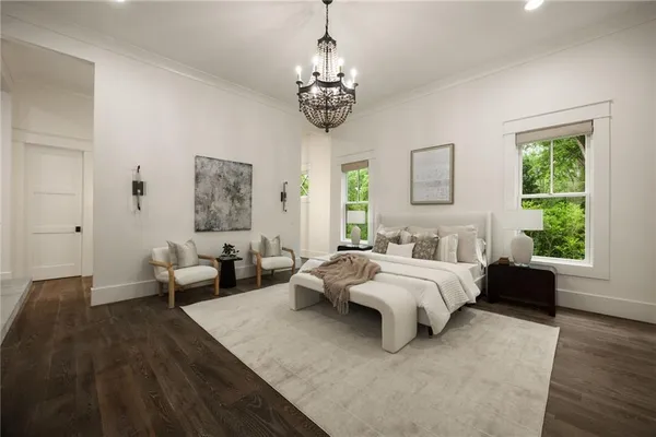 an empty room with wooden floor chandelier and windows