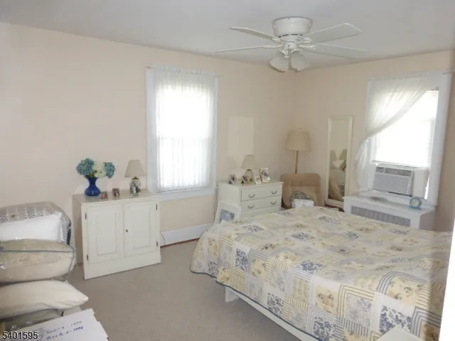 a bedroom with a white bed and a chandelier