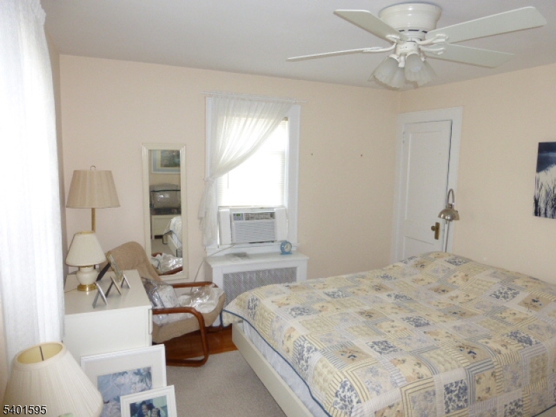 18 Sherman Avenue, Unit B Morris Plains, NJ 07950 - Photo 15 of 24 a bedroom with a bed and a chandelier