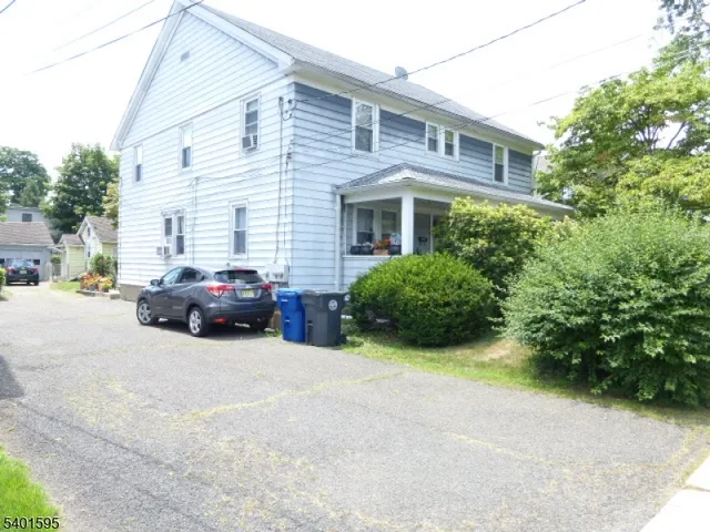 a view of a car parked in front of a white house