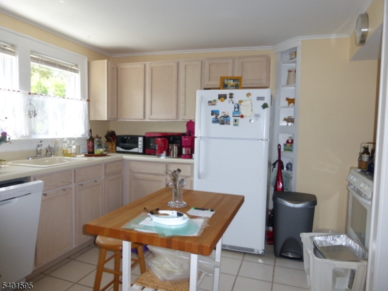 18 Sherman Avenue, Unit B Morris Plains, NJ 07950 - Photo 10 of 24 a kitchen with a refrigerator and a stove top oven