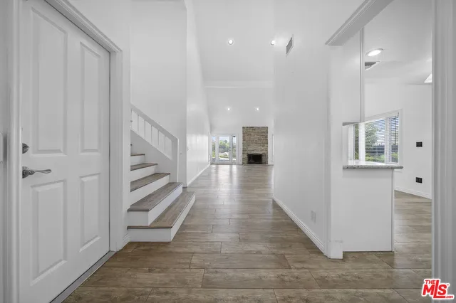 a view of a hallway with wooden floor and staircase
