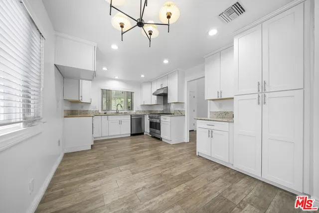 a kitchen with white cabinets and white stainless steel appliances