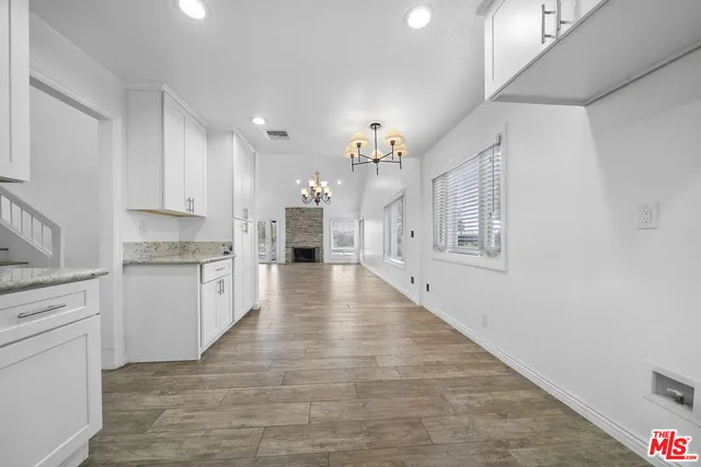 a view of kitchen with granite countertop cabinets and refrigerator