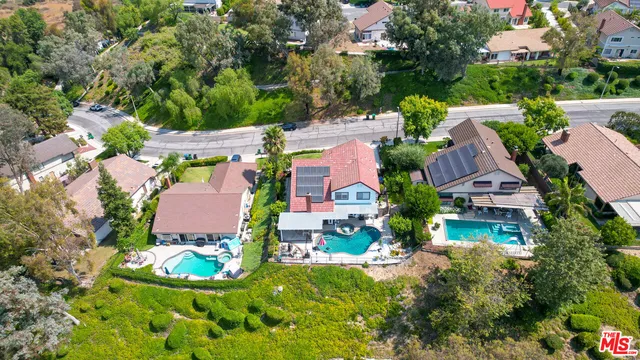 an aerial view of a house with a garden and lake view