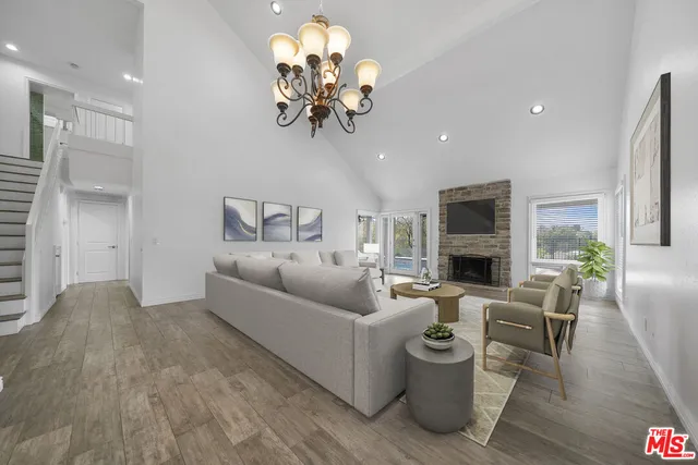 a living room with furniture a chandelier and a fireplace