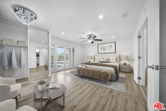 a spacious bedroom with a bed a couch and a chandelier