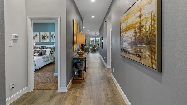 a view of a hallway and a livingroom with furniture