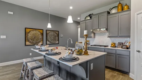 a kitchen with stainless steel appliances kitchen island granite countertop a refrigerator a stove a sink a dining table and chairs with wooden floor