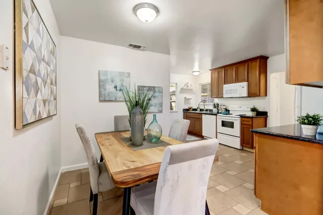 a dining room with furniture and kitchen view
