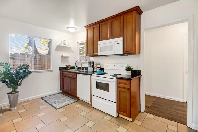 a kitchen with stainless steel appliances granite countertop a stove a sink and a microwave