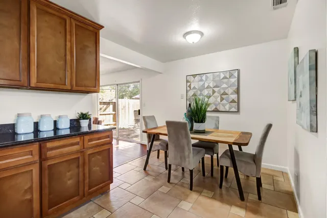 a kitchen with stainless steel appliances granite countertop a table and chairs in it