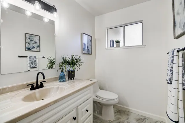 a bathroom with a toilet sink and mirror