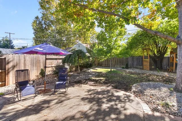 a patio with a table and chairs under an umbrella