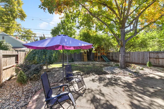 a patio with a table and chairs under an umbrella