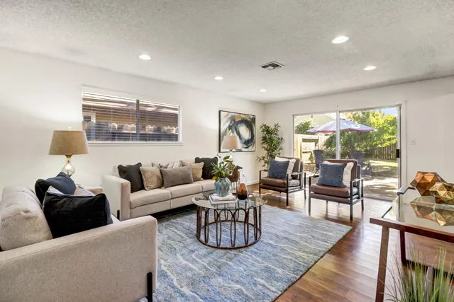 a living room with furniture and a wooden floor