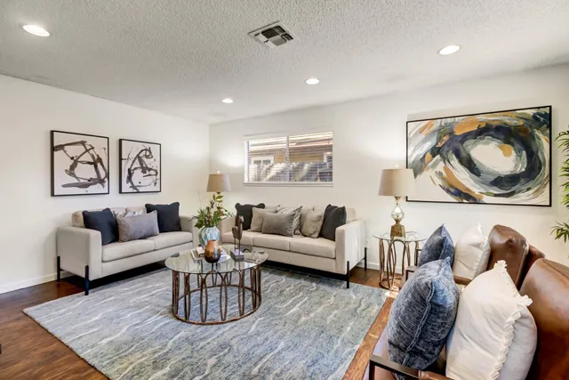 a living room with furniture and a wooden floor