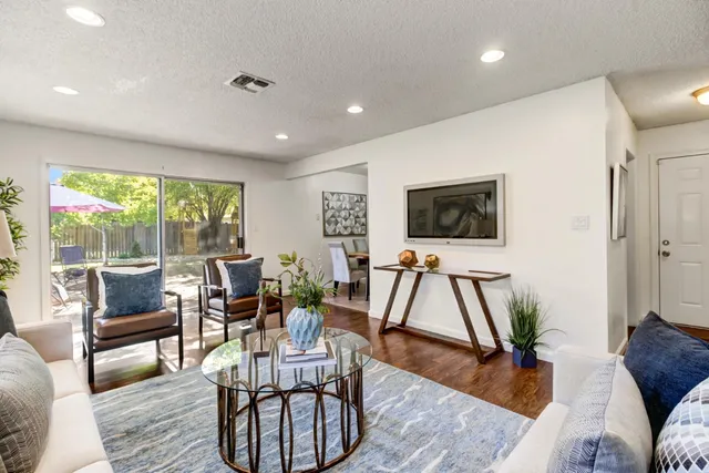 a living room with furniture a large window and a flat screen tv