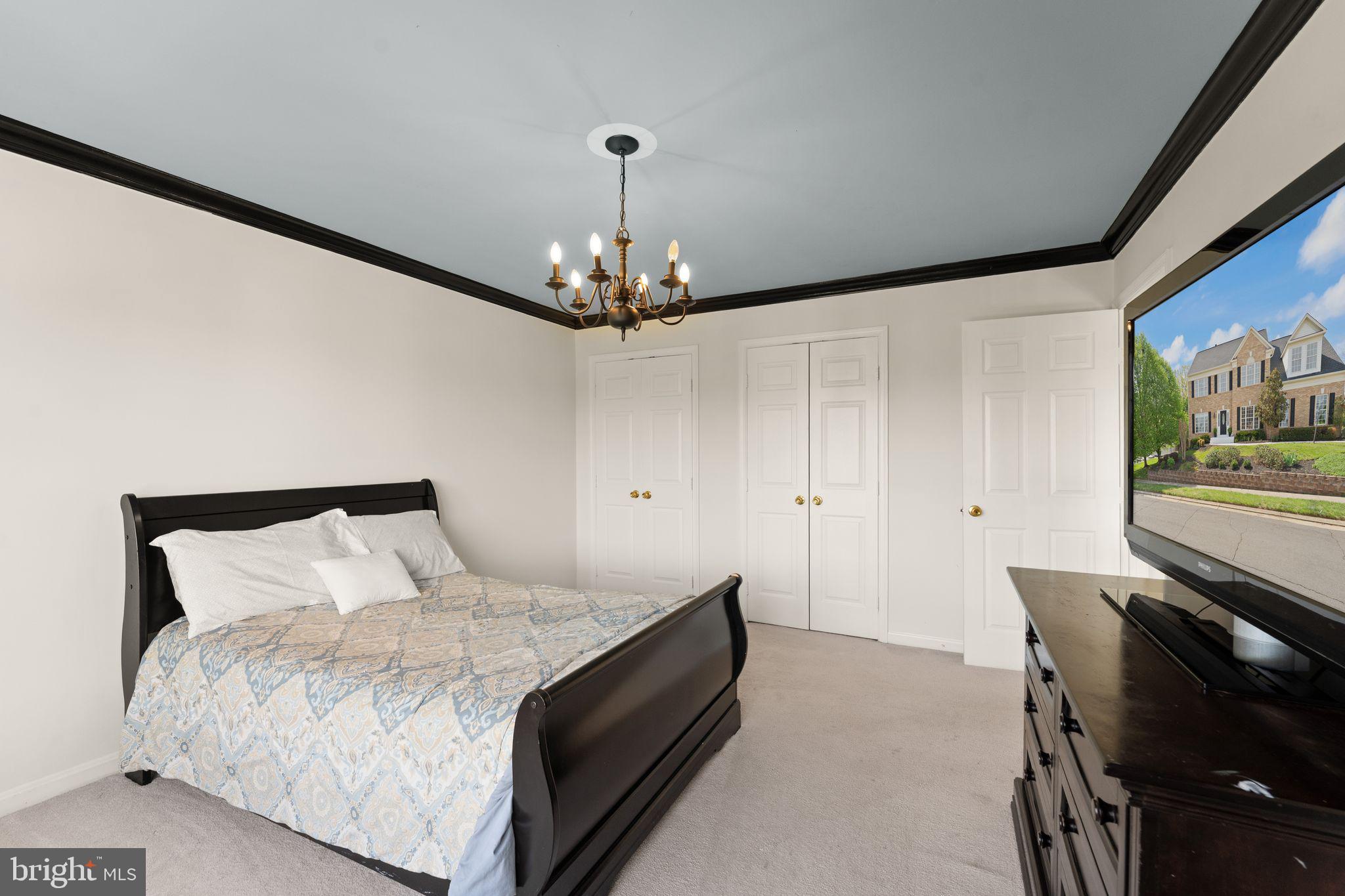43179 Parkers Ridge Drive Leesburg, VA 20176 - Photo 60 of 108 a spacious bedroom with a bed and a chandelier