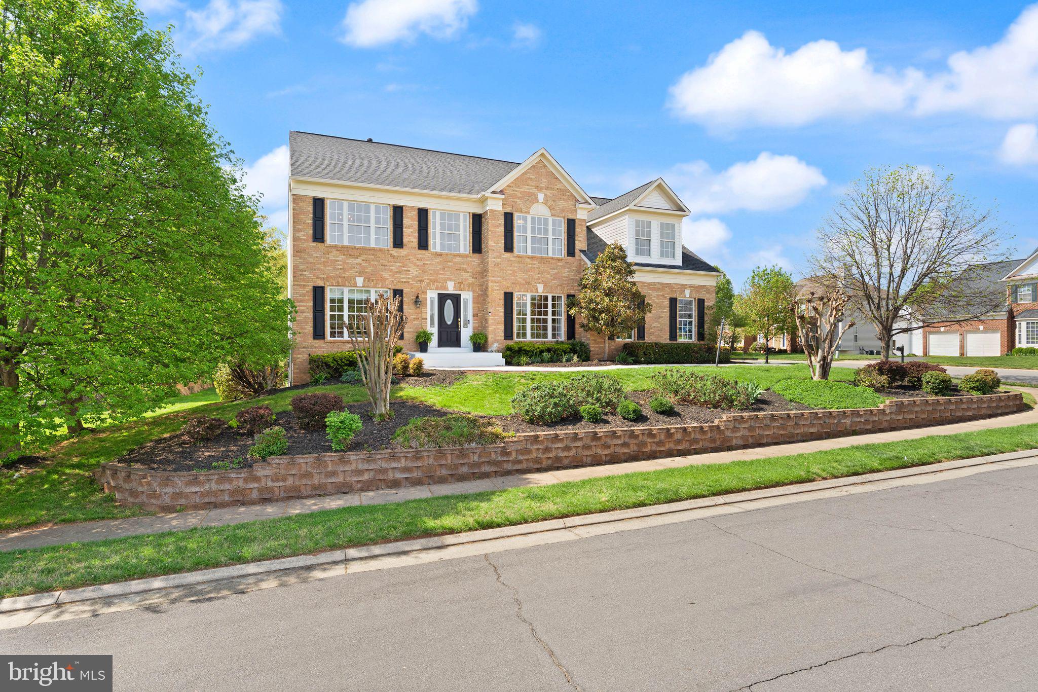 43179 Parkers Ridge Drive Leesburg, VA 20176 - Photo 6 of 108 a view of a white house next to a yard with big trees