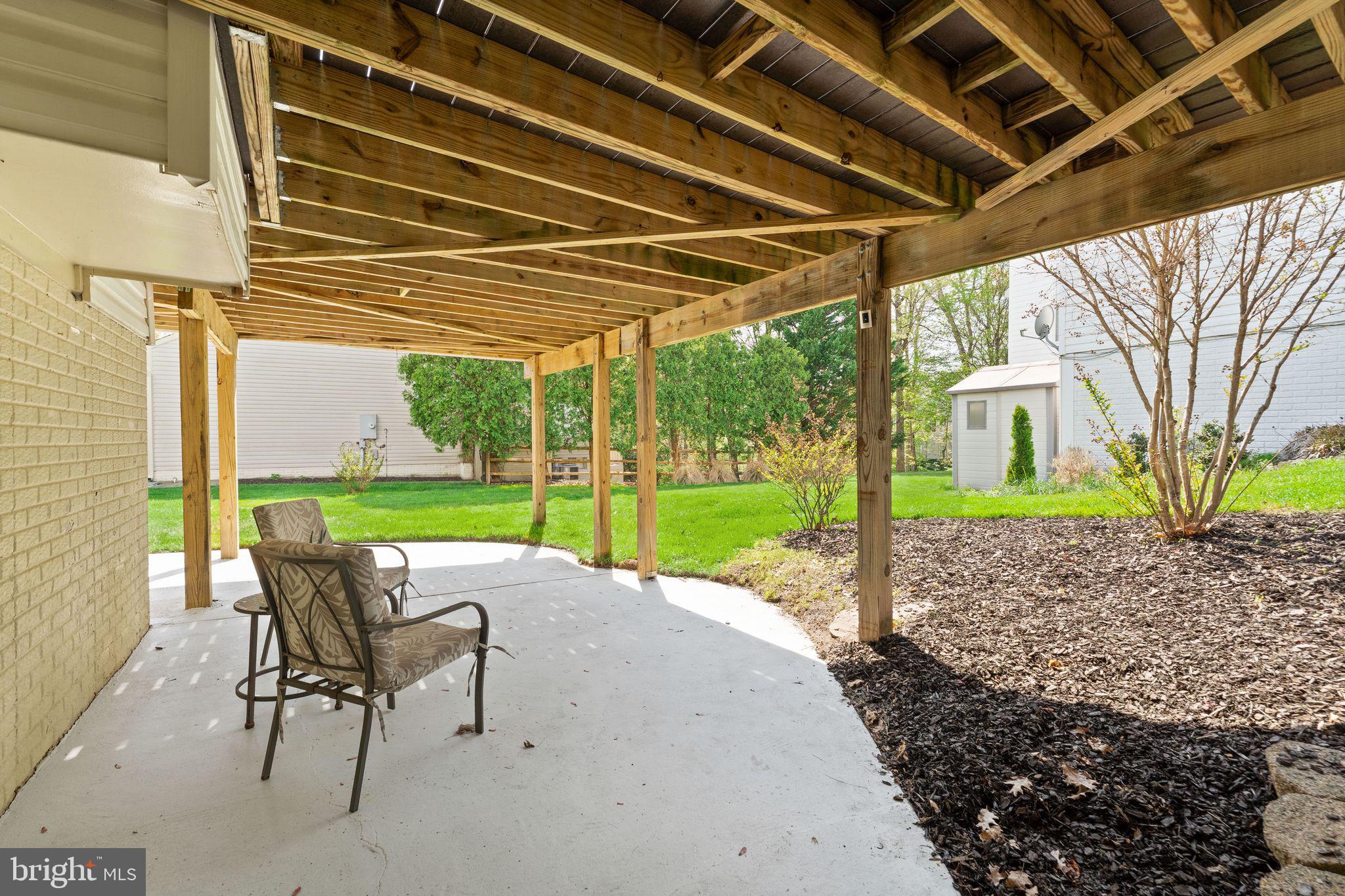 43179 Parkers Ridge Drive Leesburg, VA 20176 - Photo 87 of 108 a view of a backyard with table and chairs under an umbrella with a small yard