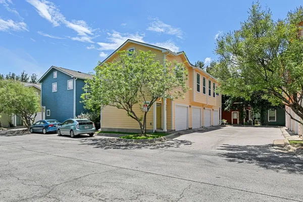 a front view of a house with a yard and tree s