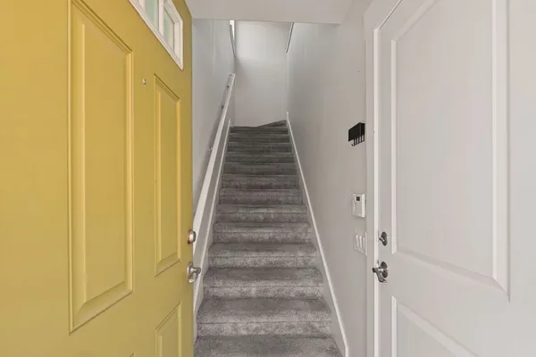a view of a hallway with wooden floor and staircase