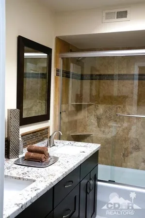 a bathroom with a granite countertop sink and a mirror