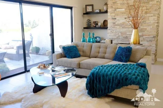 a living room with furniture and a floor to ceiling window