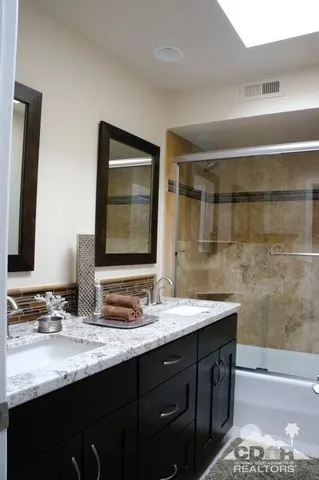 a bathroom with a sink double vanity granite and a mirror
