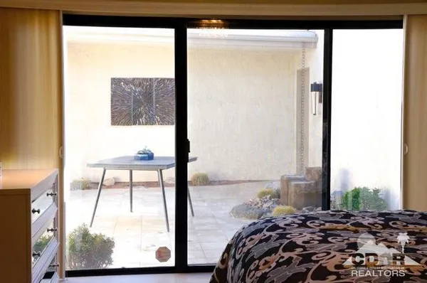 a bedroom with a bed and a large window