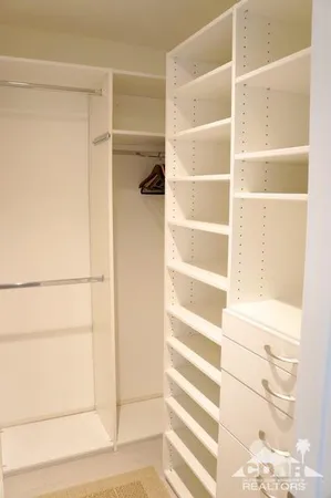 a view of walk in closet with empty racks