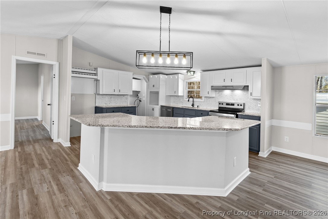 1750 John Russell Road Raeford, NC 28376 - Photo 12 of 39 a kitchen with kitchen island granite countertop a white cabinets and refrigerator
