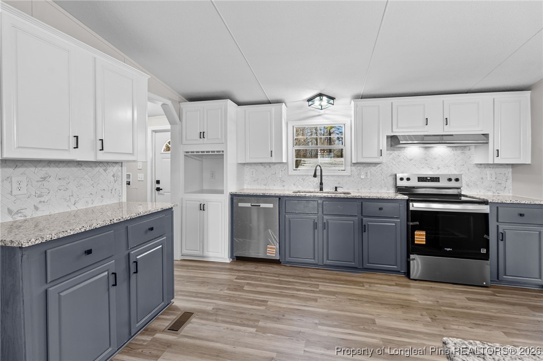 1750 John Russell Road Raeford, NC 28376 - Photo 13 of 39 a kitchen with stainless steel appliances granite countertop a stove sink and cabinets