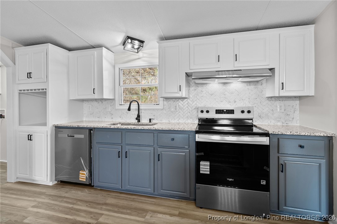 1750 John Russell Road Raeford, NC 28376 - Photo 16 of 39 a kitchen with stainless steel appliances granite countertop a sink stove and cabinets
