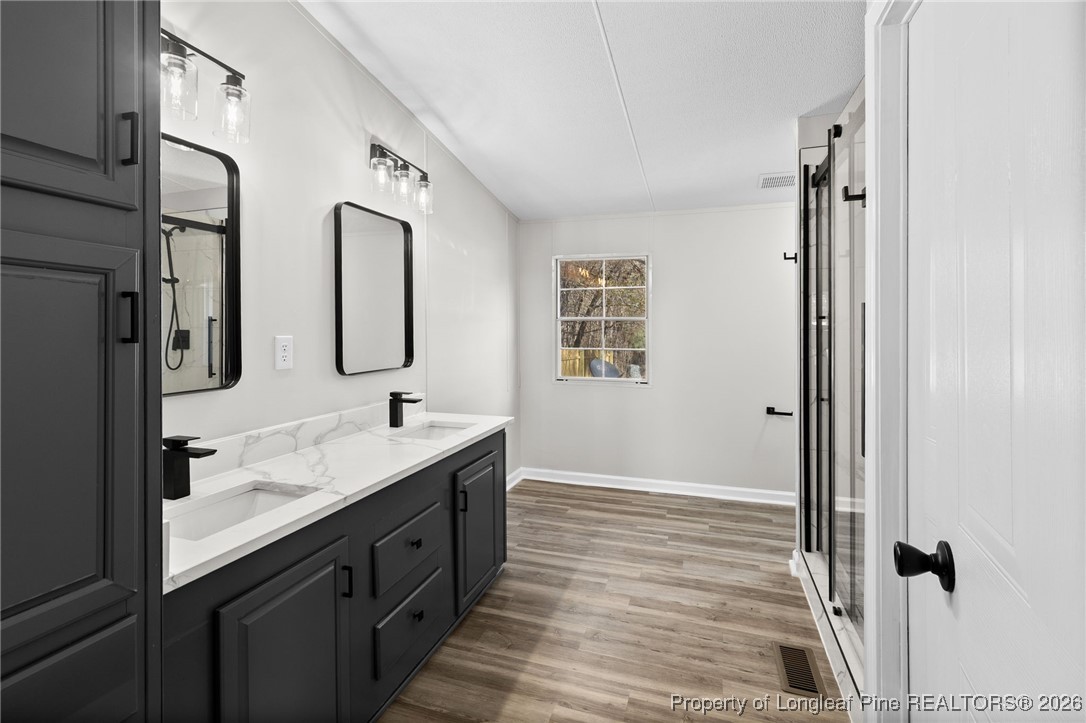 1750 John Russell Road Raeford, NC 28376 - Photo 21 of 39 a spacious bathroom with a double vanity sink a mirror and a shower