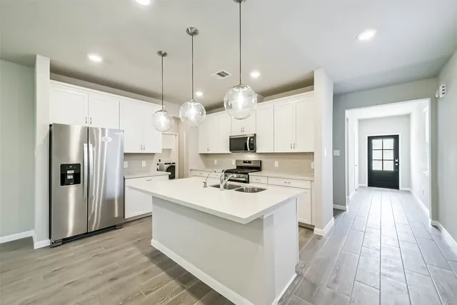 a kitchen with kitchen island a sink stainless steel appliances and cabinets