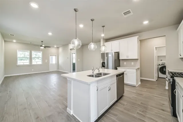 a kitchen with a sink stove and wooden floor