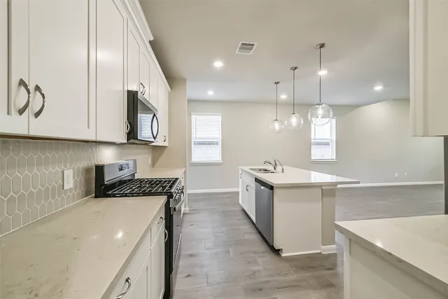 a kitchen with a sink a stove and cabinets