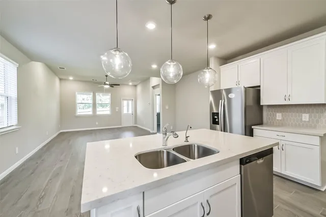 a kitchen that has a lot of cabinets and stainless steel appliances