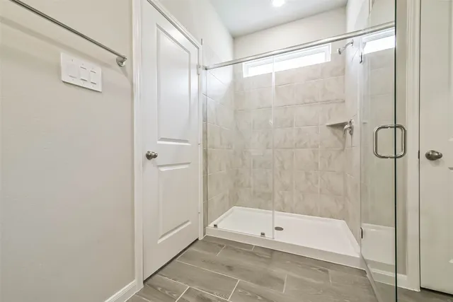 a bathroom with a shower and a glass door