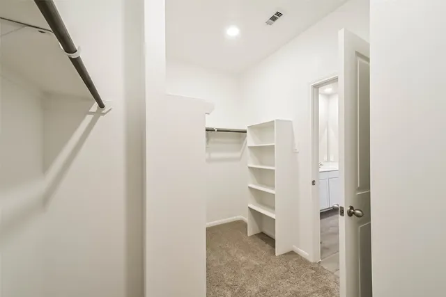 a view of walk in closet with empty racks