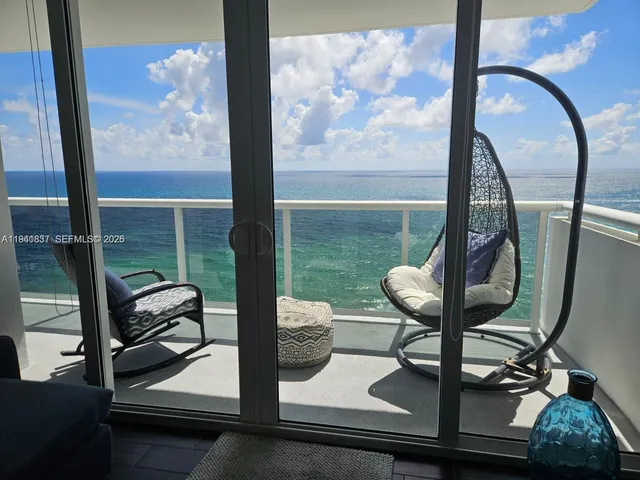 a view of a balcony with chair and a potted plant