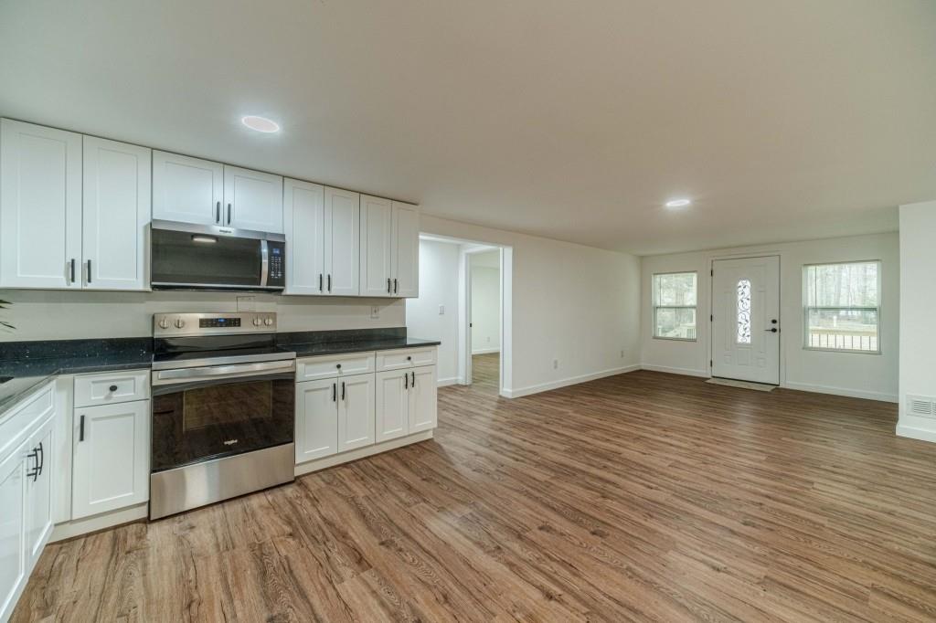 3617 Bob White Lane Southwest Loganville, GA 30052 - Photo 13 of 48 a view of kitchen with granite countertop wooden floor stainless steel appliances and a window
