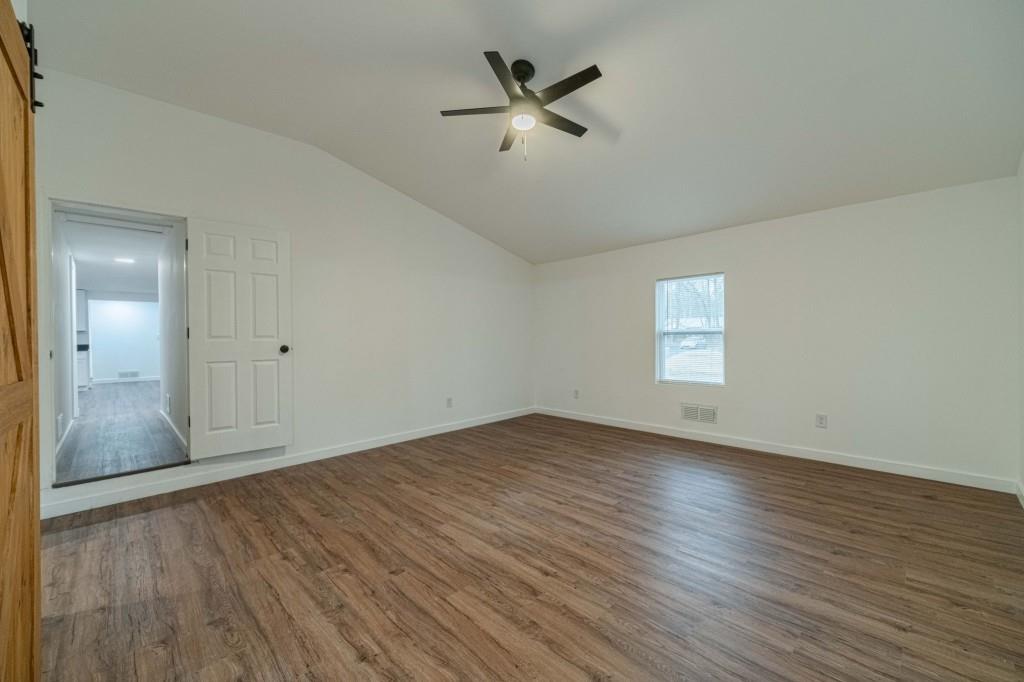 3617 Bob White Lane Southwest Loganville, GA 30052 - Photo 17 of 48 an empty room with wooden floor and a ceiling fan